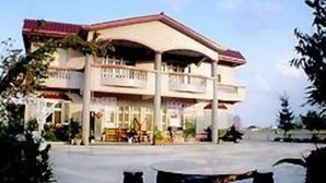 A two-story building with a red roof and a balcony on the upper floor. - Yilan Feeling Homestay B&B (Wujie)