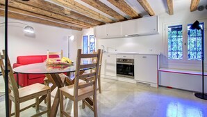 Eine moderne Küche mit weißen Schränken, einem eingebauten Backofen und einem Fenster mit dekorativen Sprossen.