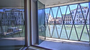 Ein Fenster mit Blick auf einen Kanal, Gebäude und ein Boot.
