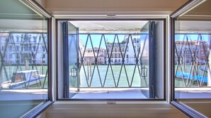 Ein Fenster mit Blick auf einen Fluss und Gebäude.
