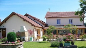 Une maison à deux étages avec une pelouse et un jardin bien entretenus.