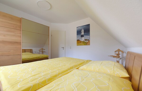 Une chambre à coucher avec un lit, une armoire, un tableau et une tête de lit en bois.