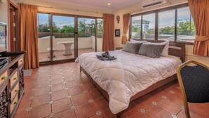 Una camera d'albergo con un letto grande, una televisione, un tavolo e una sedia.