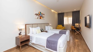 A hotel room with two beds, a desk, a chair, and a TV. - Le Wana Hotel (Dubai)