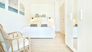 Une chambre à coucher avec un lit, des lampes de chevet, une chaise et une armoire.