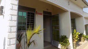 A building entrance with a reception sign, a door labeled 'D1', and potted plants outside. - Deluxe Hotel - Ishaka (Ishaka)