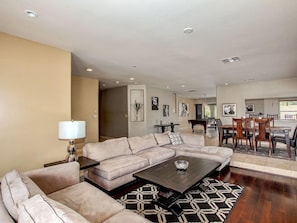 Relax in this stylish living room with a comfortable sofa, dining area, and patterned rug.