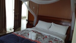 Un lit avec une couvre-lit à motifs floraux, un oreiller blanc et une couverture bleue.