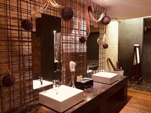A modern bathroom with two sinks, a large mirror, and a hairdryer. - Hip Spa Motel (Taichung)