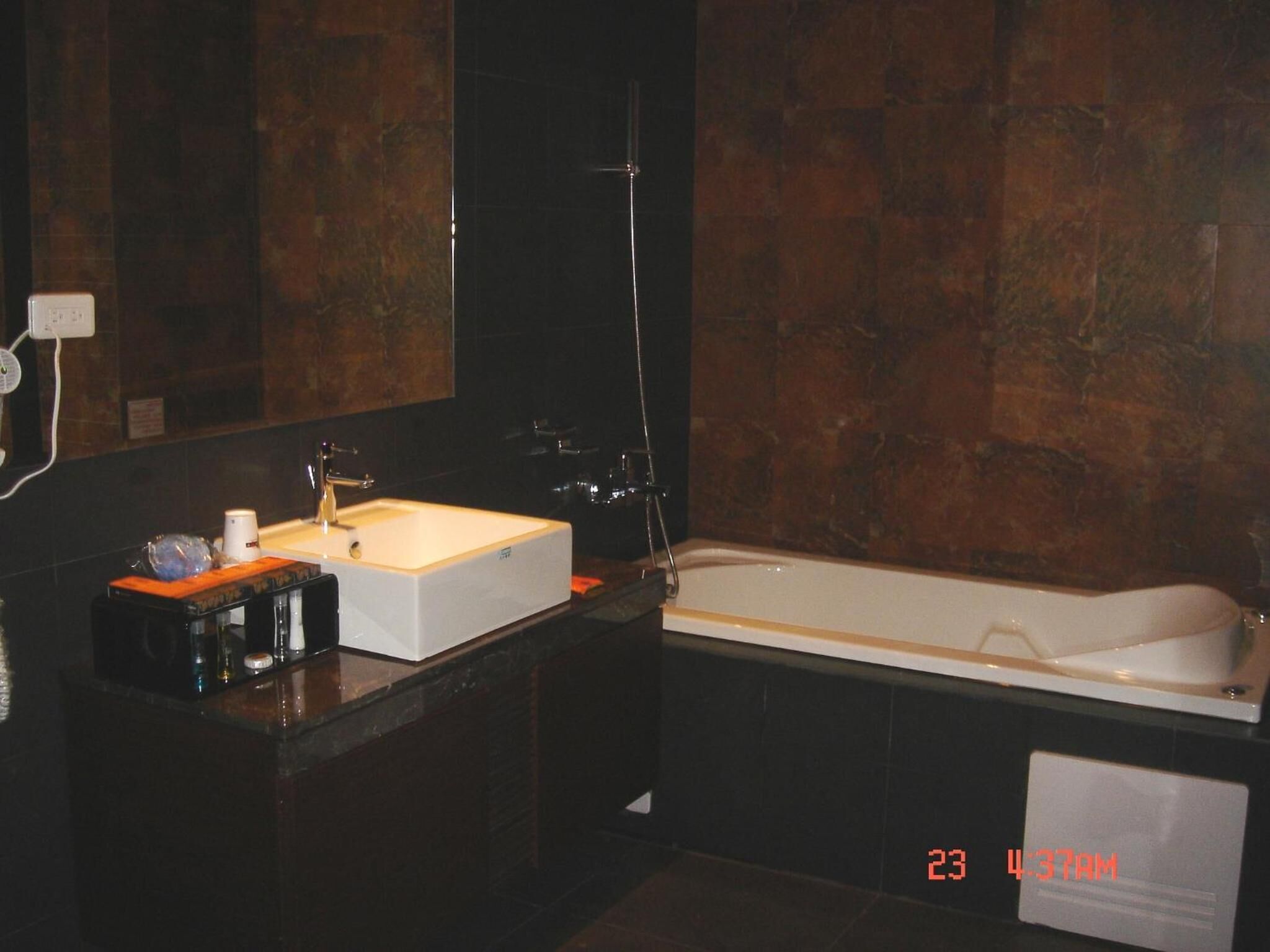 A modern bathroom with a large white bathtub, a rectangular sink, and a mirror above the sink.