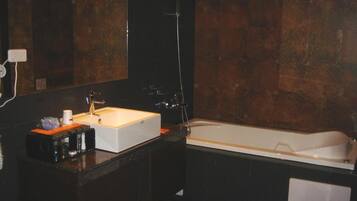 A modern bathroom with a large white bathtub, a rectangular sink, and a mirror above the sink.
