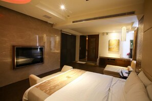 A hotel room with a bed, a TV, a desk, and a bathroom. - Hip Spa Motel (Taichung)