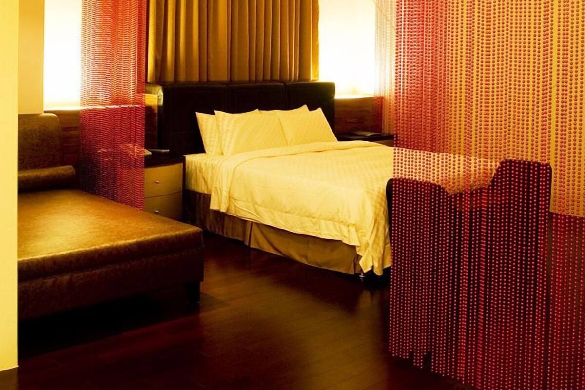Una habitación de hotel moderna con cama, sofá y escritorio.