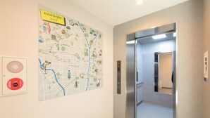 A map of Kyoto City on the wall, an elevator, and a fire alarm panel. - M’s Hotel Kyoto Station Taruya (Kyoto)