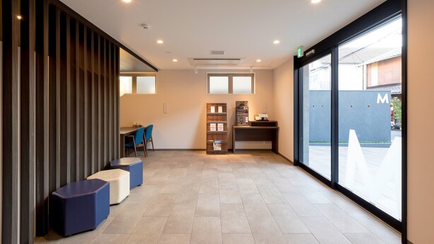 A reception area with a counter, seating, and a large window. - M’s Hotel Kyoto Station Taruya (Kyoto)