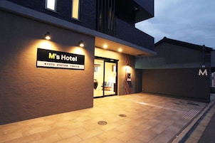 The exterior of M's Hotel at Kyoto Station Tarrya, featuring a modern entrance with illuminated signage and a clean, tiled pavement.