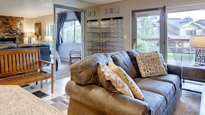 A living room with a brown leather sofa, a wooden bench, and a stone wall.