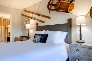 A hotel room with a bed, a nightstand, a lamp, and a ski lift mounted on the wall. - Ski In & Walk Out-Patio with Slope Views-HotTub (Steamboat Springs)