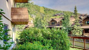 A residential area with houses, a wooden deck, and a mountain backdrop.