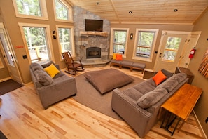 Cozy living area with a stone fireplace, flat-screen TV, and comfortable sofas.