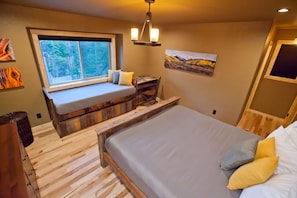 Relax in a serene space with a large bed, wooden headboard, and a cozy reading nook.