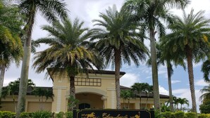 A golf club sign with a building in the background. - Vacation in paradise at Lely Resort (Naples)