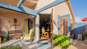 Un espace extérieur accueillant, aménagé avec un banc et des chaises, une table à manger et un petit jardin.