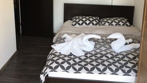 Ett hotellrum med en mörk träramad säng, mönstrat sänglinne och en dörr till vänster.