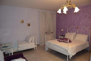 A bedroom with two beds, a desk, and a chair.