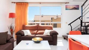 Un salon moderne avec un canapé, une table à manger et un escalier.