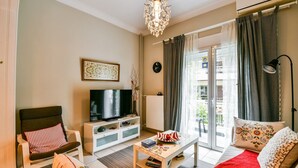 A living room with a TV, sofa, and coffee table. - Star Acropolis apartment in Acropolis (Athens)