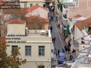 A narrow street with buildings on both sides, leading to a plaza. - Star Acropolis apartment in Acropolis (Athens)