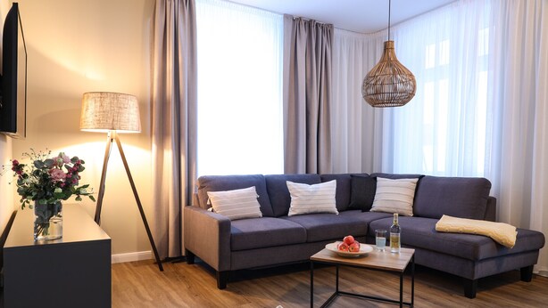 Una sala de estar moderna con un sofá modular, una mesa de centro y una lámpara de pie.