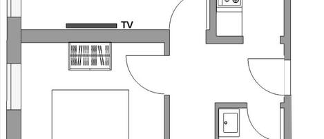 A floor plan of a hotel with a TV in the living area, a kitchenette, a bathroom, and a small dining area.