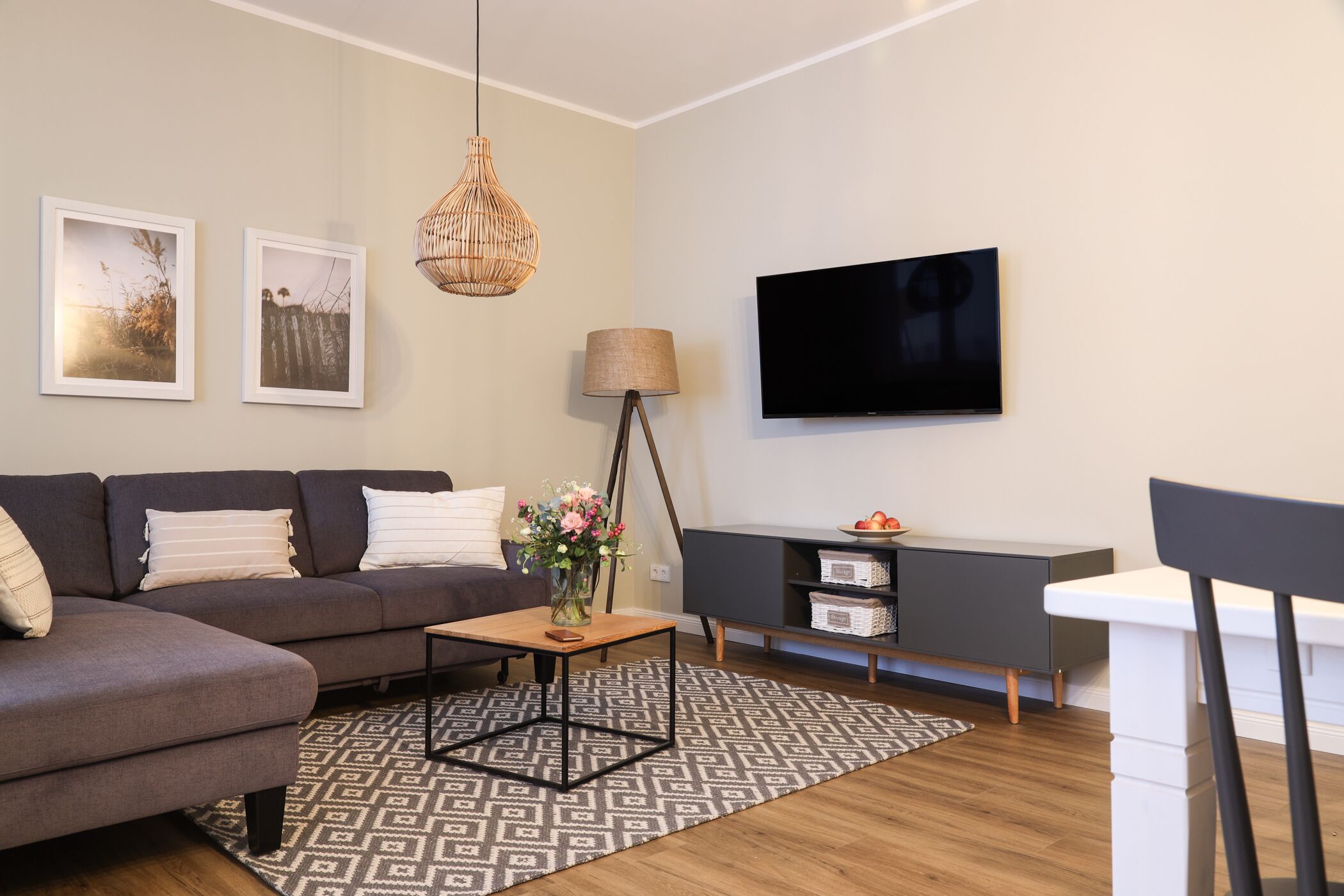 Een moderne woonkamer met een bank, salontafel, televisie en lamp.