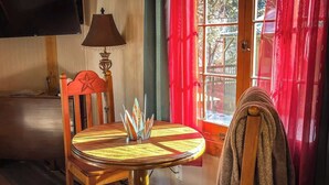 Une pièce chaleureuse avec une table en bois, une lampe et une chaise ornée d’un motif en étoile.