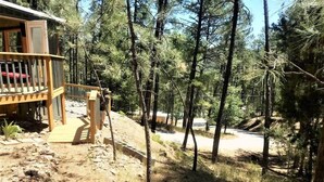 Eine Holzhütte mit einer Holzdiele und einem Feldweg, der zu einer Straße führt.