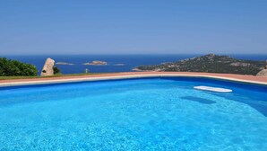 A clear blue pool with a view of the sea and a rocky landscape. - Villa Lara 3 (Arzachena)