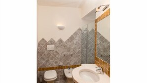 A bathroom with a toilet, bidet, and sink.