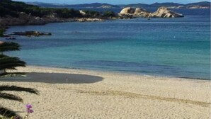 A beach with clear turquoise water, rocky outcrops, and a sandy shore. - Villa La Silvaredda (Arzachena)