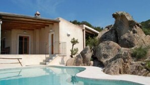 A modern house with a swimming pool, surrounded by large rocks and greenery. - Villa La Silvaredda (Arzachena)