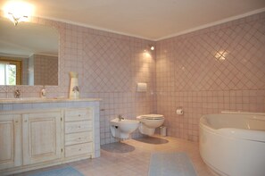 A bathroom with a sink, bidet, toilet, and bathtub. - Villa Monti di Mola (Arzachena)