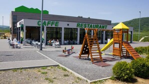 Restaurante Caffe com área externa e espaço de recreação infantil.