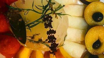 Una bandeja de frutas con melocotones, manzanas y un centro de mesa de vidrio decorativo.
