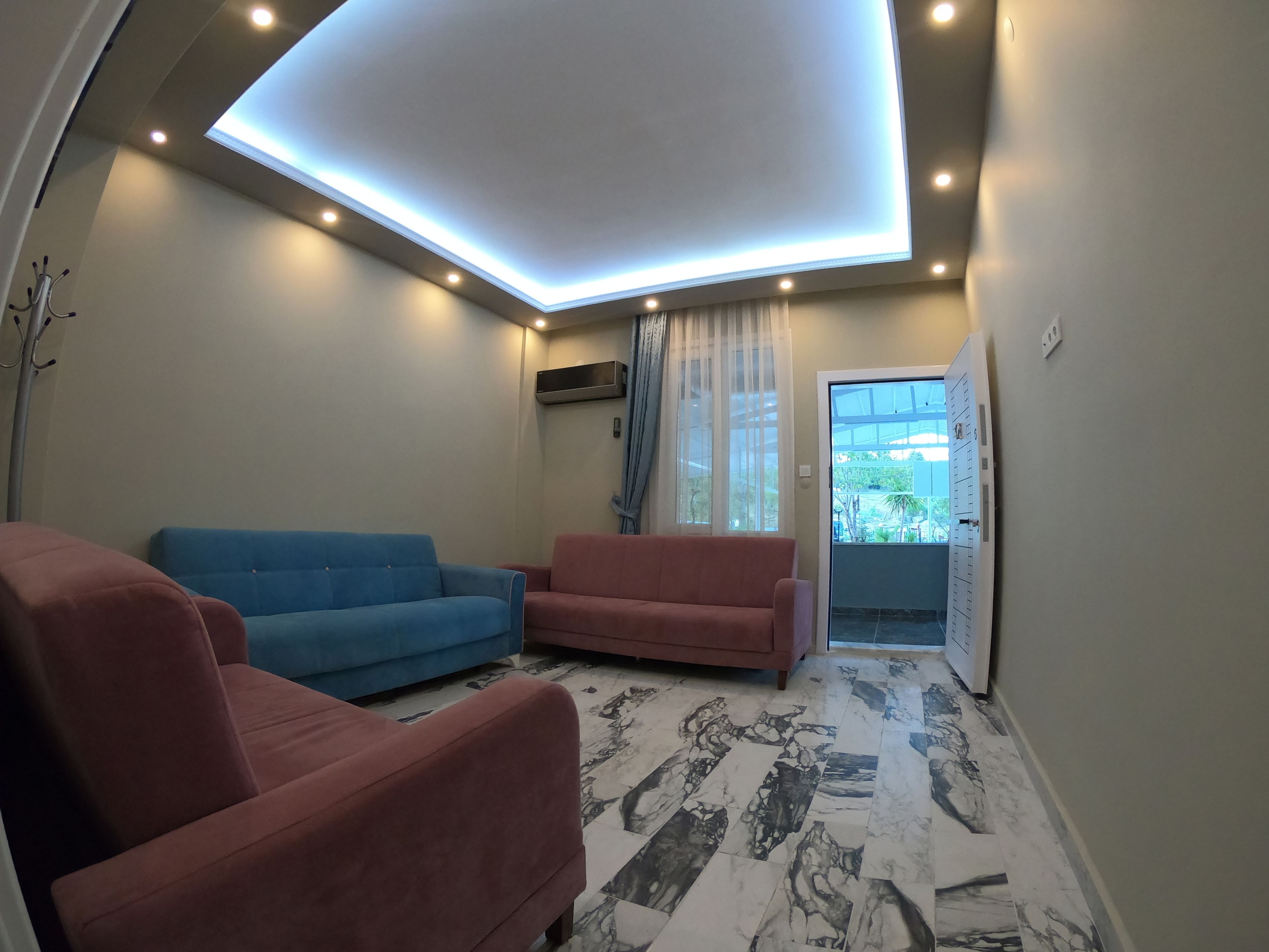 A living room with two sofas, a ceiling light, and a view of the outdoors.