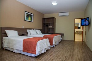 A hotel room with two beds, a TV, a wardrobe, and a painting on the wall. - K Hotel (Presidente Venceslau)
