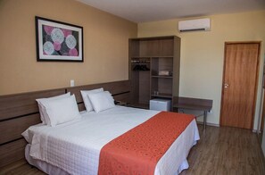 A hotel room with a bed, a wardrobe, a desk, and a door. - K Hotel (Presidente Venceslau)