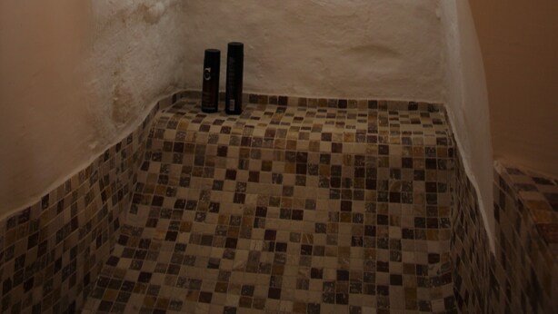 A bathroom with a checkered floor, a small window, and two bottles on the floor. - Typical Ostuni House - Free WiFi - Mini Spa (Ostuni)