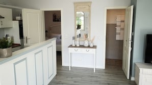 A modern kitchen with white cabinetry, a wooden countertop, and a built-in oven.