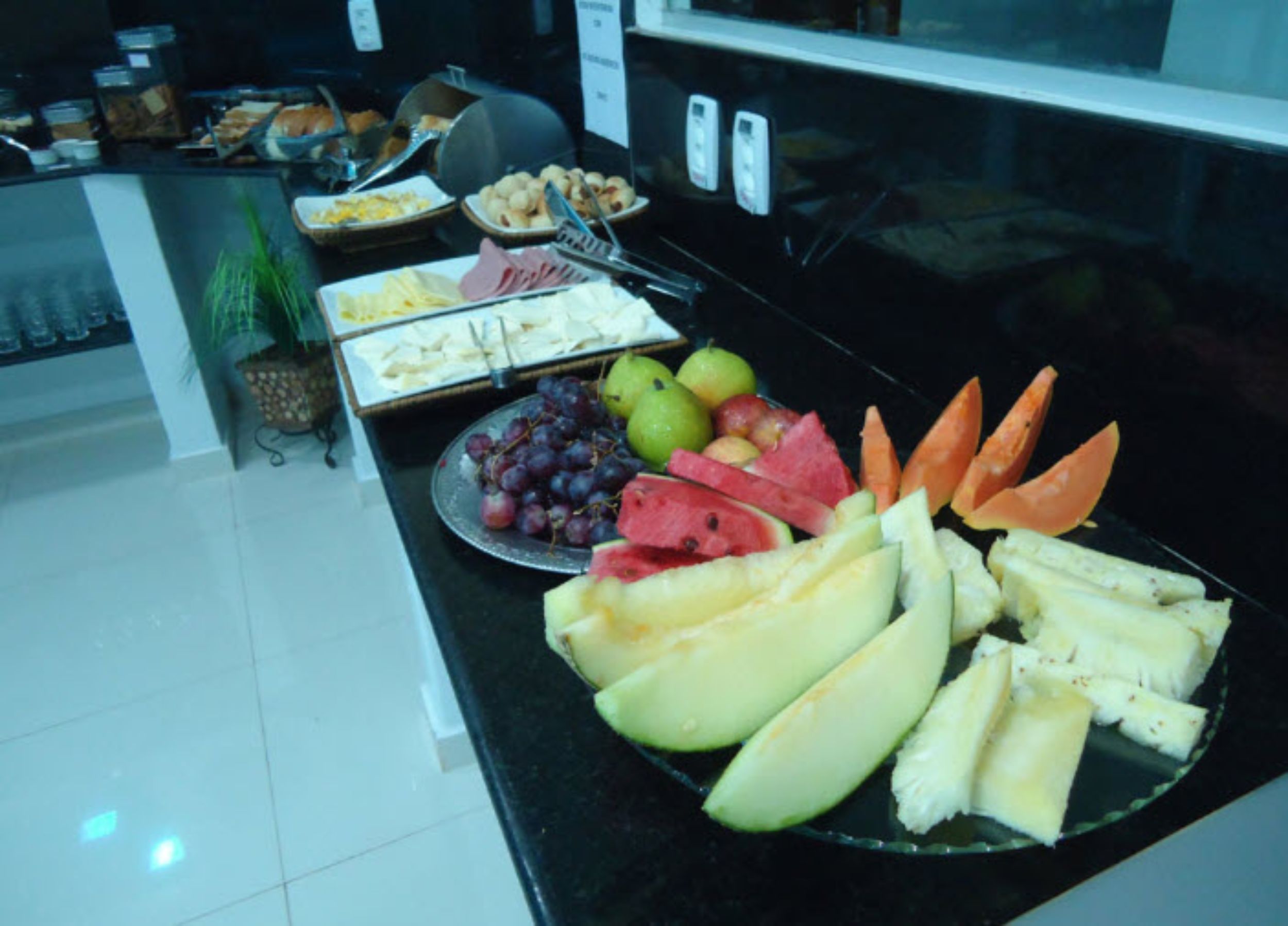 A buffet with various fruits and cheeses.